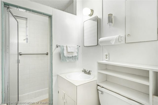 bathroom with tiled shower, vanity, and toilet