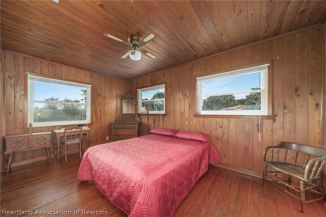 bedroom with wood-type flooring, ceiling fan, and wooden walls