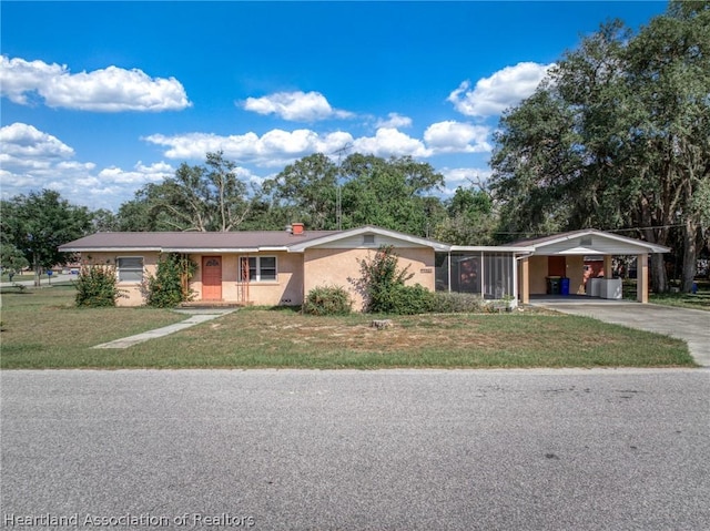 ranch-style house featuring a carport and a front yard