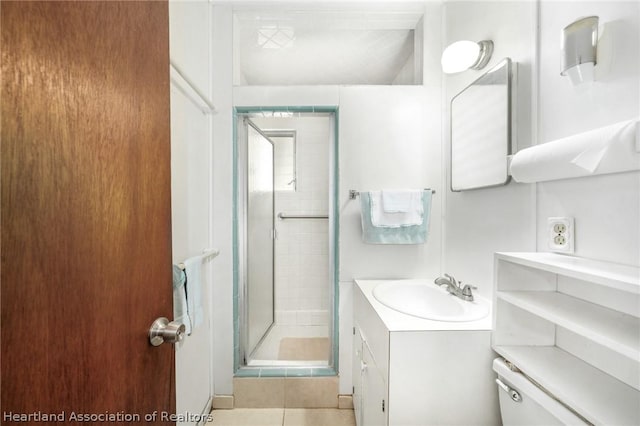 bathroom featuring tile patterned floors, vanity, toilet, and walk in shower