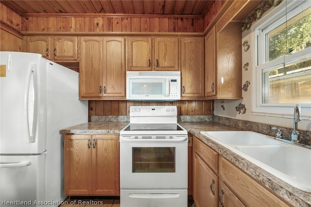 kitchen featuring white appliances, wood ceiling, and sink