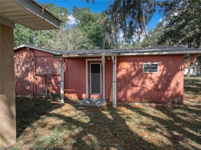 rear view of property featuring a lawn