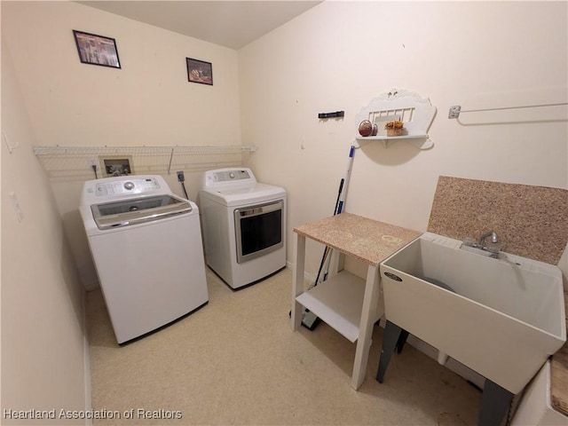 laundry area featuring laundry area, washing machine and dryer, and a sink