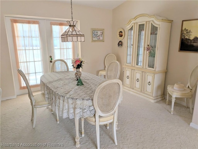 dining space with light colored carpet and baseboards