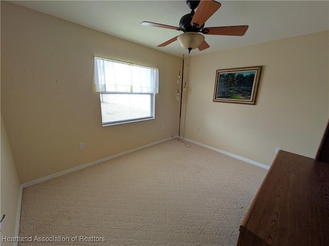 empty room featuring light colored carpet and ceiling fan