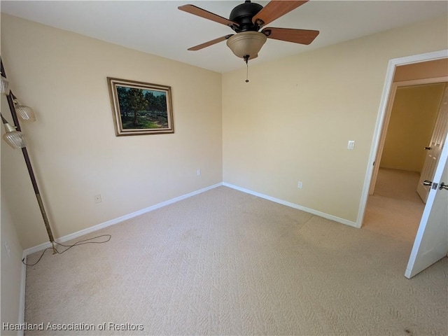 unfurnished bedroom with light colored carpet, a ceiling fan, and baseboards