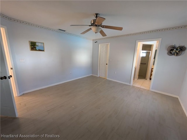 unfurnished bedroom with visible vents, wood finished floors, baseboards, and ensuite bathroom