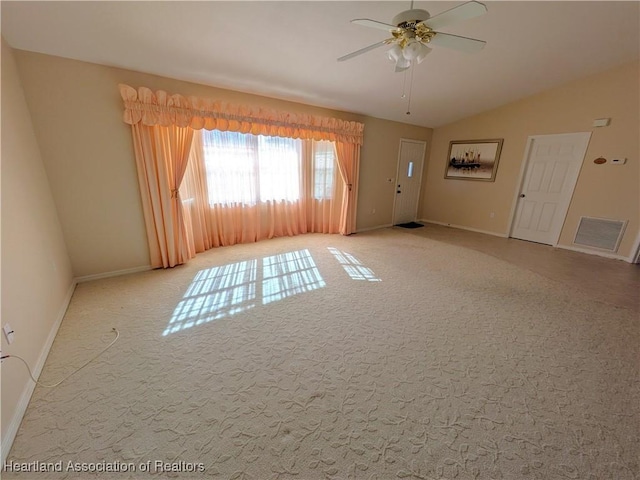 spare room with visible vents, baseboards, ceiling fan, vaulted ceiling, and carpet flooring