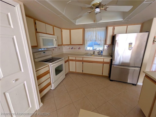 kitchen featuring light countertops, light tile patterned flooring, white appliances, a ceiling fan, and a sink