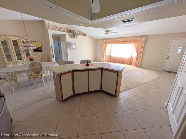 living room with visible vents, light carpet, light tile patterned floors, lofted ceiling, and ceiling fan