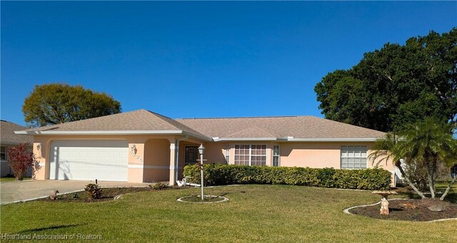 ranch-style home featuring a garage and a front lawn