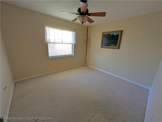 empty room featuring a ceiling fan, baseboards, and light carpet