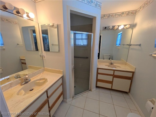 bathroom featuring toilet, vanity, tile patterned floors, and walk in shower