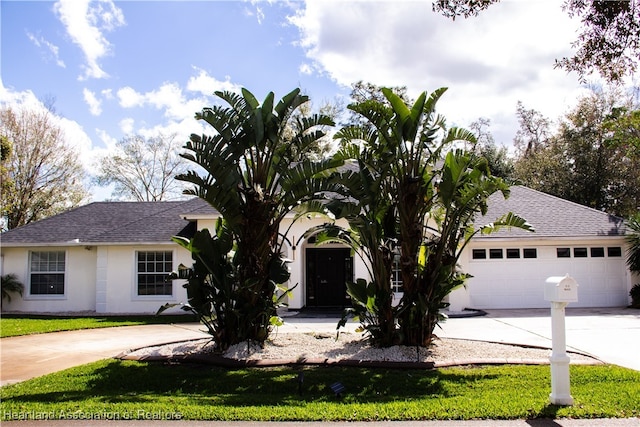 view of front of property with a front yard and a garage