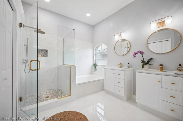 bathroom with vanity and shower with separate bathtub