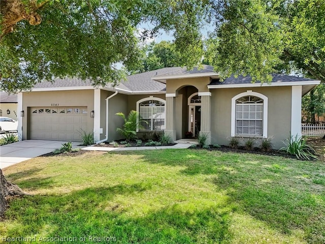 ranch-style house with a garage and a front lawn