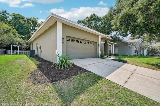 view of front of house with a front yard, a garage, and cooling unit