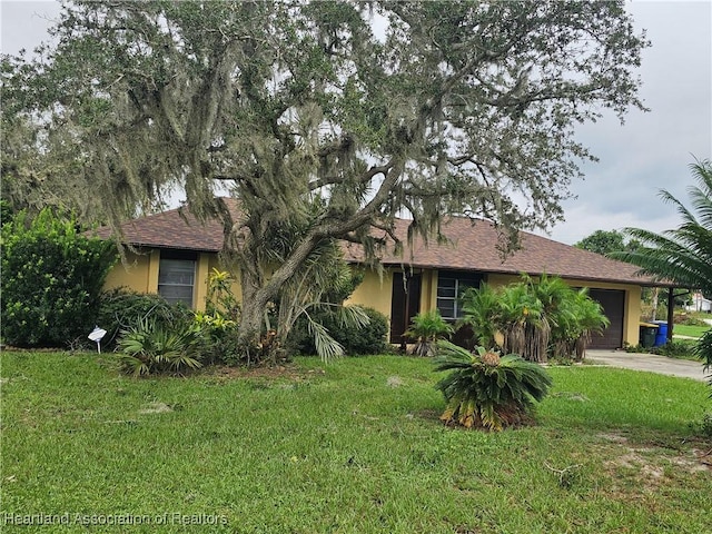 obstructed view of property with a front yard and a garage