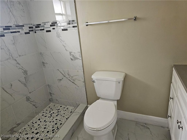 bathroom with a tile shower and toilet