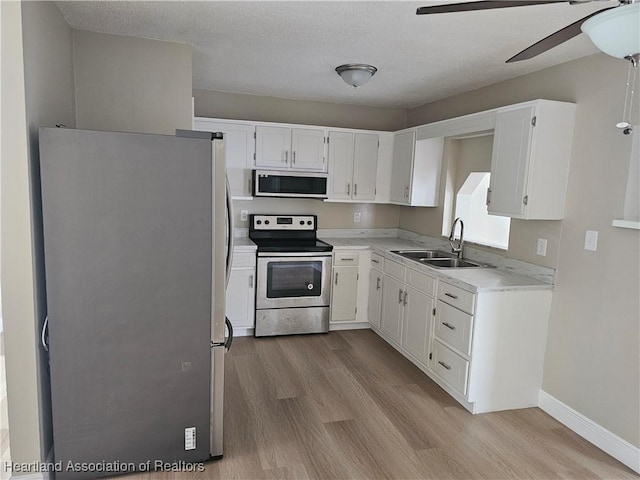 kitchen with white cabinetry, sink, light wood-type flooring, and appliances with stainless steel finishes