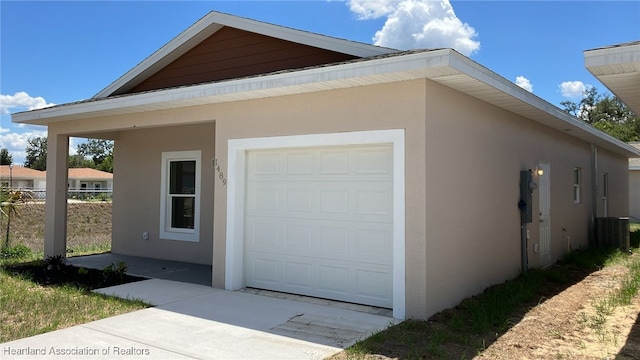 view of side of property with central AC unit, fence, and stucco siding