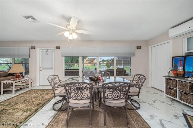 dining space with marble finish floor, visible vents, a wall unit AC, and ceiling fan