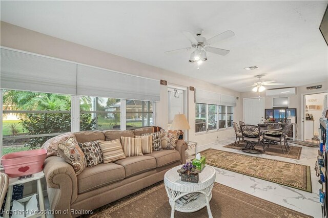 living area featuring a ceiling fan, an AC wall unit, and visible vents