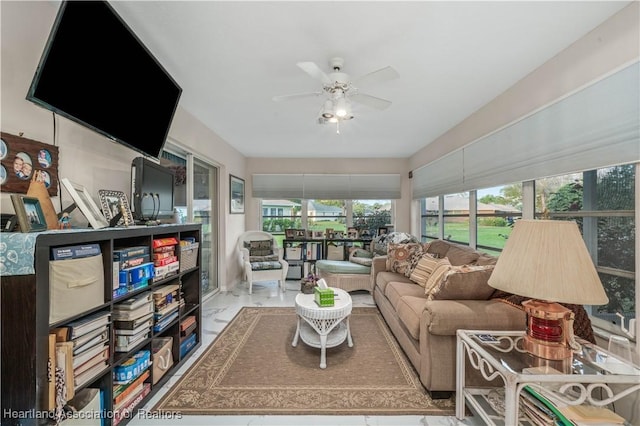 living area with ceiling fan and marble finish floor