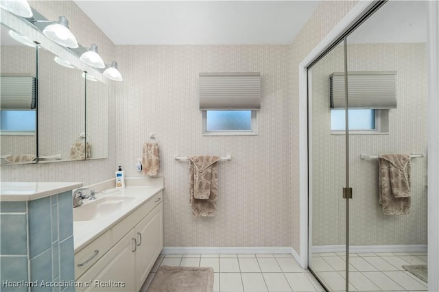 full bathroom with vanity, baseboards, a shower stall, tile patterned floors, and wallpapered walls