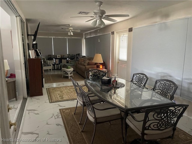 dining space with ceiling fan, marble finish floor, and visible vents