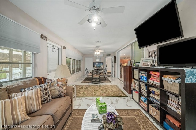 living area featuring marble finish floor and ceiling fan