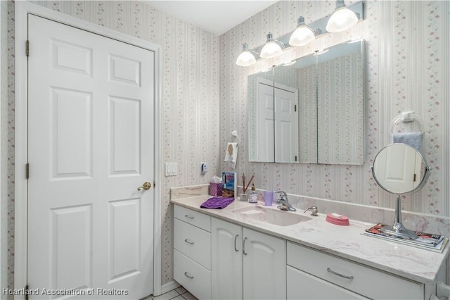 bathroom with vanity and wallpapered walls