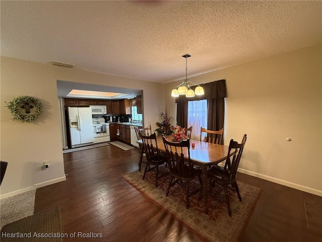 dining area with visible vents, dark wood-type flooring, a textured ceiling, a chandelier, and baseboards