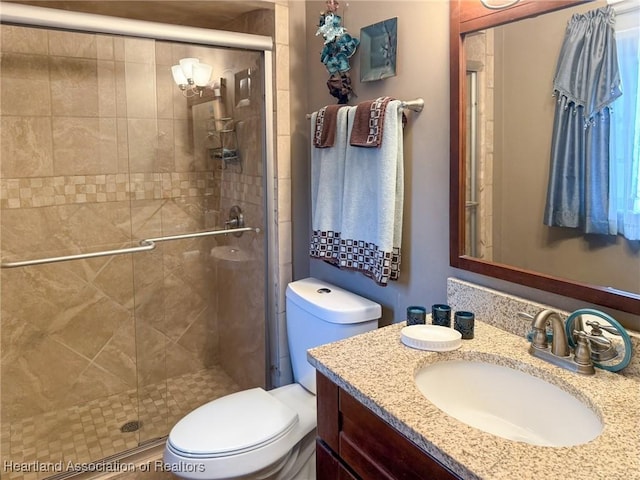 bathroom featuring a stall shower, vanity, and toilet