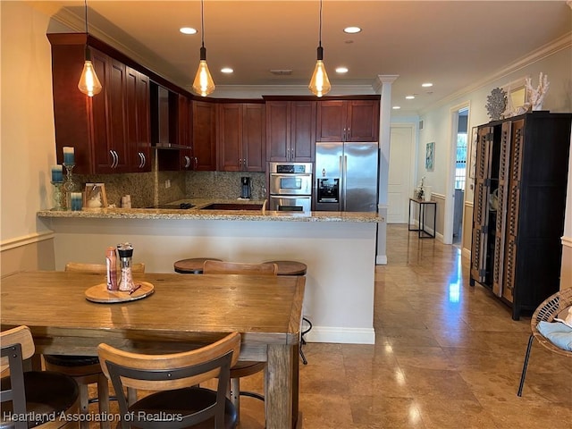 kitchen with stainless steel appliances, kitchen peninsula, wall chimney exhaust hood, and hanging light fixtures