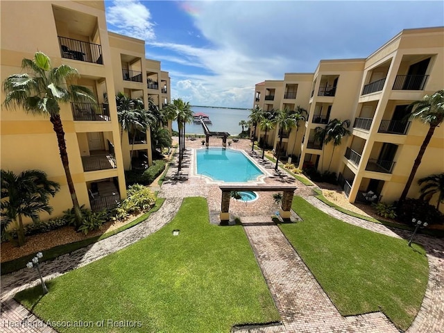 view of pool featuring a yard and a water view