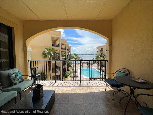 balcony featuring outdoor lounge area and a water view