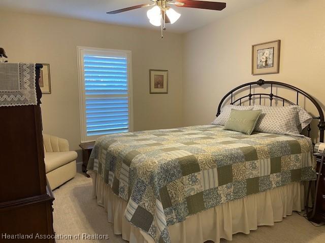 bedroom featuring light carpet and ceiling fan