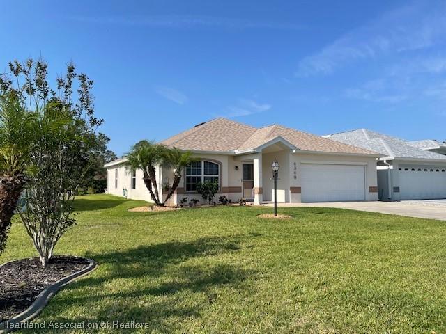 single story home with a front lawn and a garage