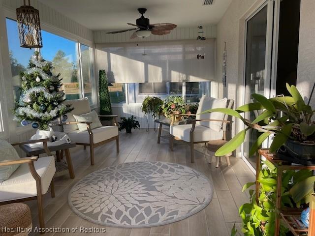 sunroom / solarium featuring ceiling fan