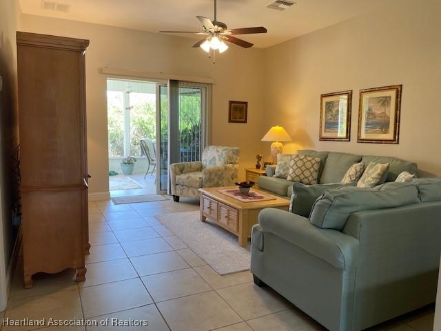 tiled living room with ceiling fan