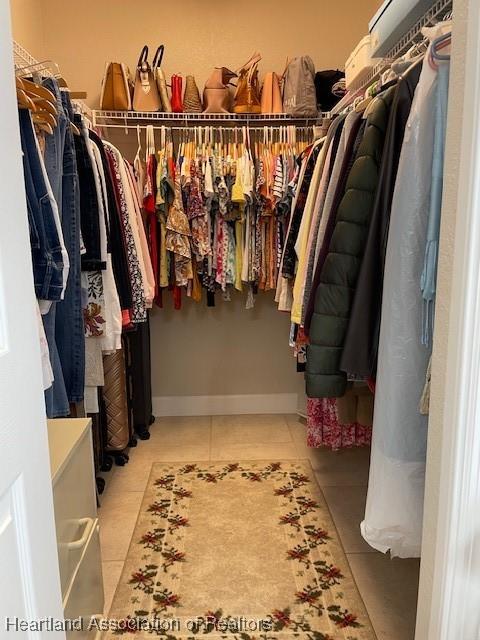 spacious closet with light tile patterned floors