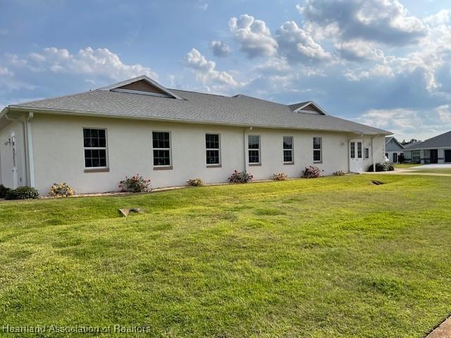 back of property featuring a yard