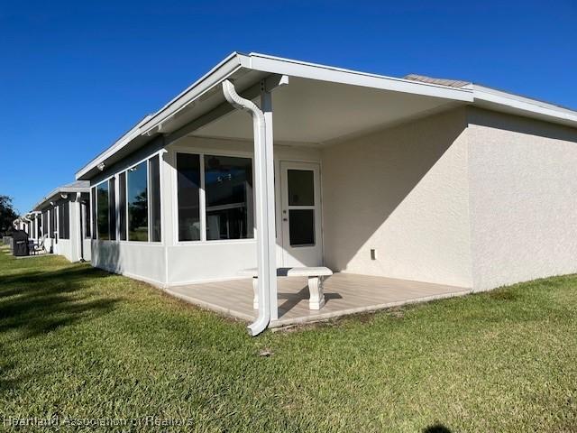 back of house featuring a lawn