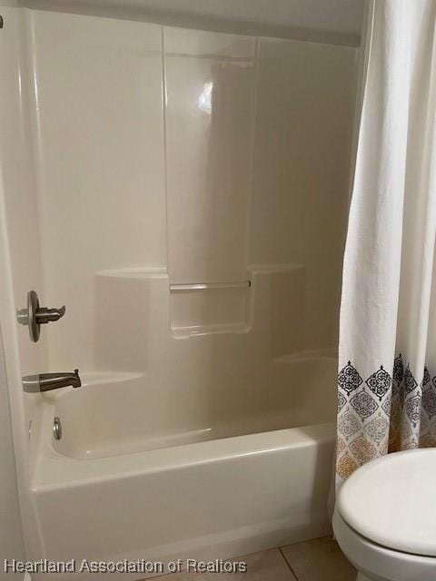 bathroom featuring toilet, tile patterned flooring, and shower / bathtub combination with curtain