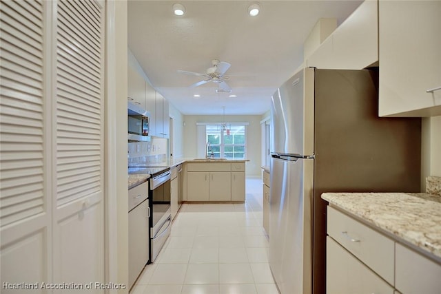 134 Bimini St NE, Lake Placid, FL 33852 - kitchen featuring appliances with stainless steel finishes, a peninsula, ceiling fan, recessed lighting, and light stone counters