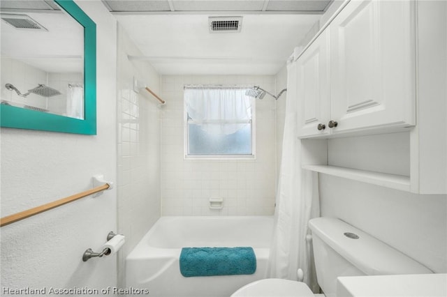 bathroom featuring shower / bathtub combination with curtain and toilet