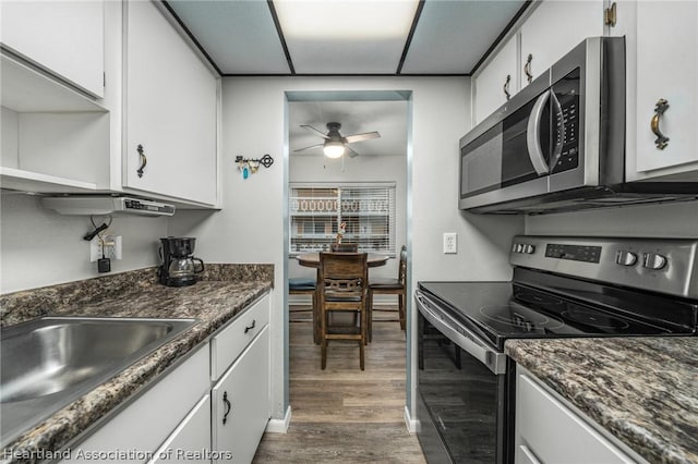 kitchen featuring white cabinets, appliances with stainless steel finishes, dark hardwood / wood-style floors, and sink