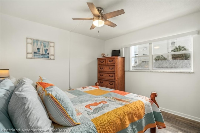 bedroom featuring multiple windows, ceiling fan, and wood-type flooring