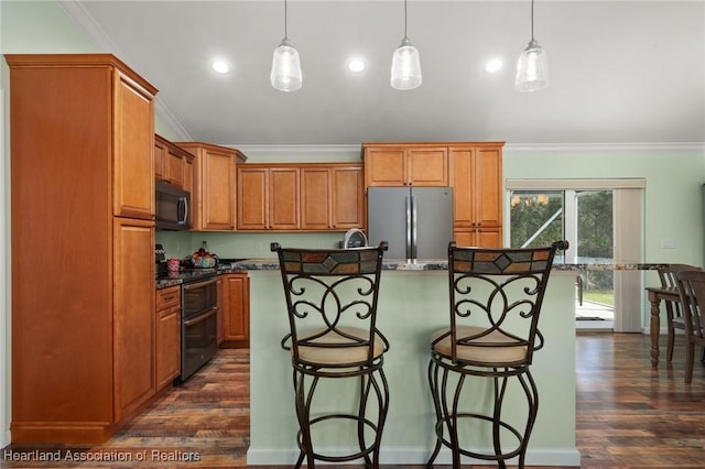 kitchen featuring hanging light fixtures, a kitchen breakfast bar, black / electric stove, stainless steel fridge, and a kitchen island with sink